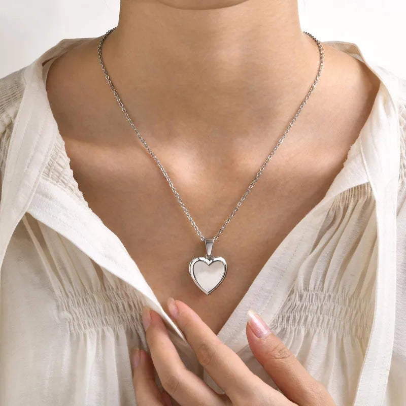 Collar con relicario de corazón y concha nácar.Color plateado. Acero inoxidable.