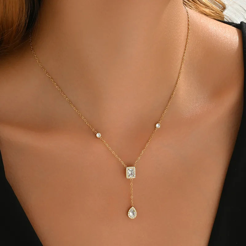 Collar con dije largo con circonias. Color dorado. Acero inoxidable.