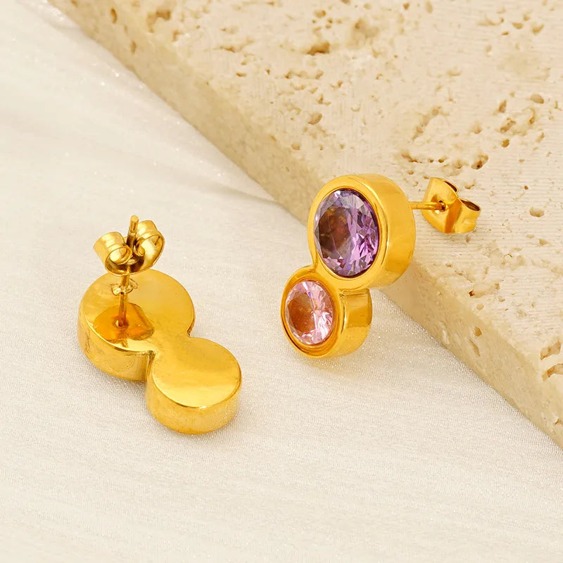 Aretes doble circulo con circonias morada y rosa. Color dorado. Acero inoxidable.