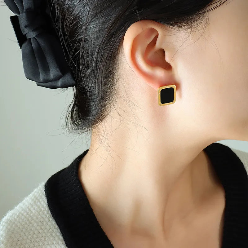 B16 - Aretes cuadros con centro negro. Color dorado. Acero inoxidable.
