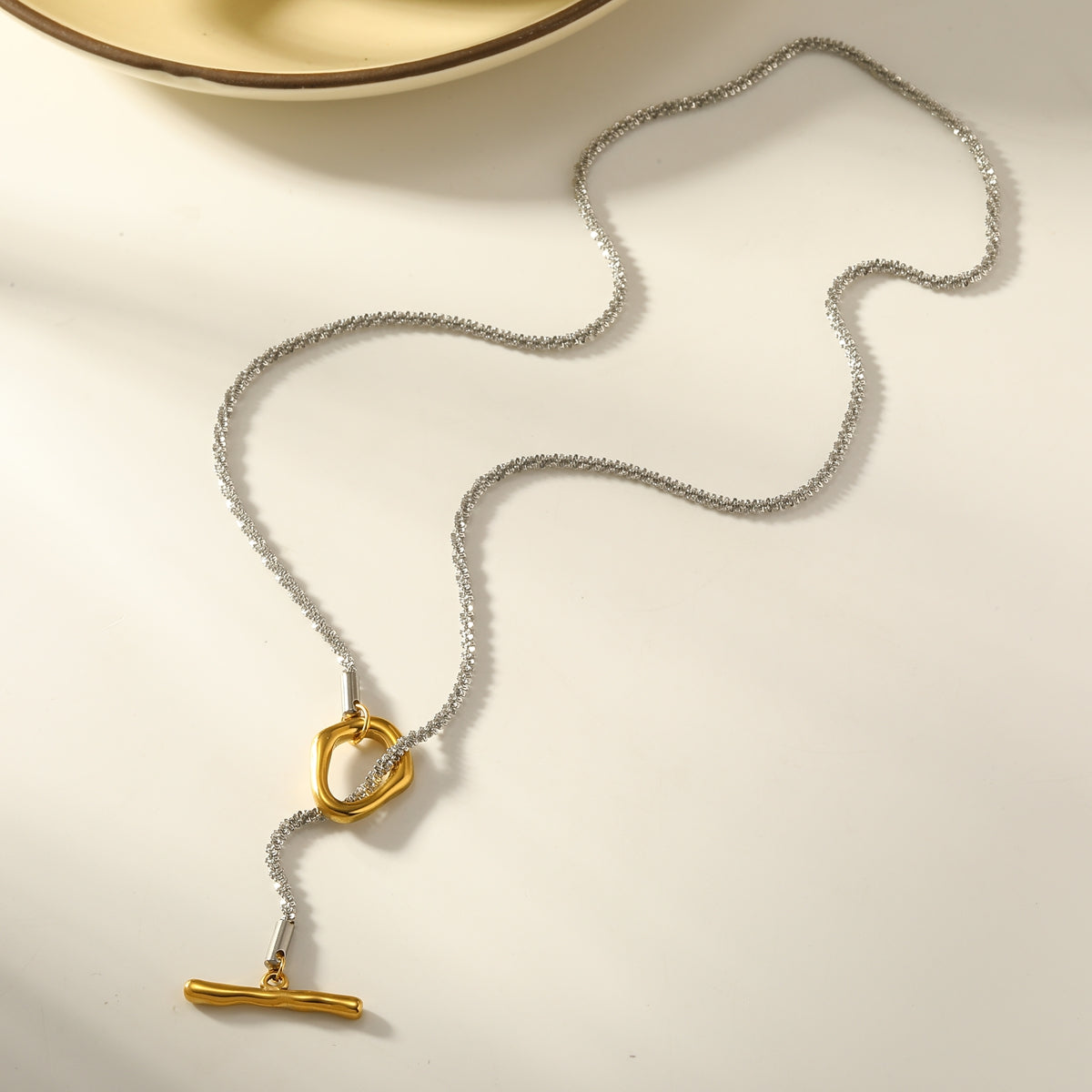 B23 - Collar con cierre dije. Color plateado con dorado. Acero inoxidable.