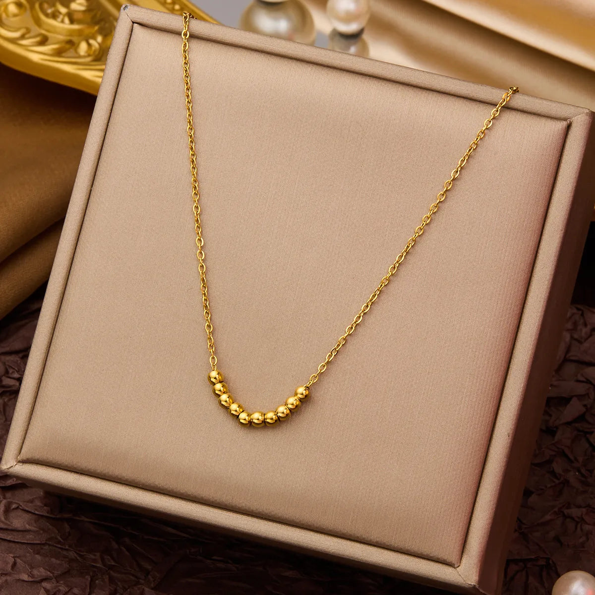 D08 - Collar con dijes de bolitas. Color dorado. Acero inoxidable.