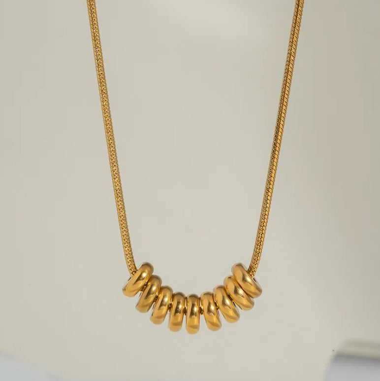 E04 - Collar con aros. Color dorado. Acero inoxidable.