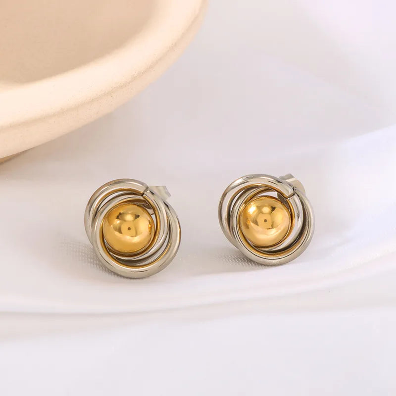 G13 - Aretes de varios circulos con esfera al centro. Color plateado con dorado. Acero inoxidable.