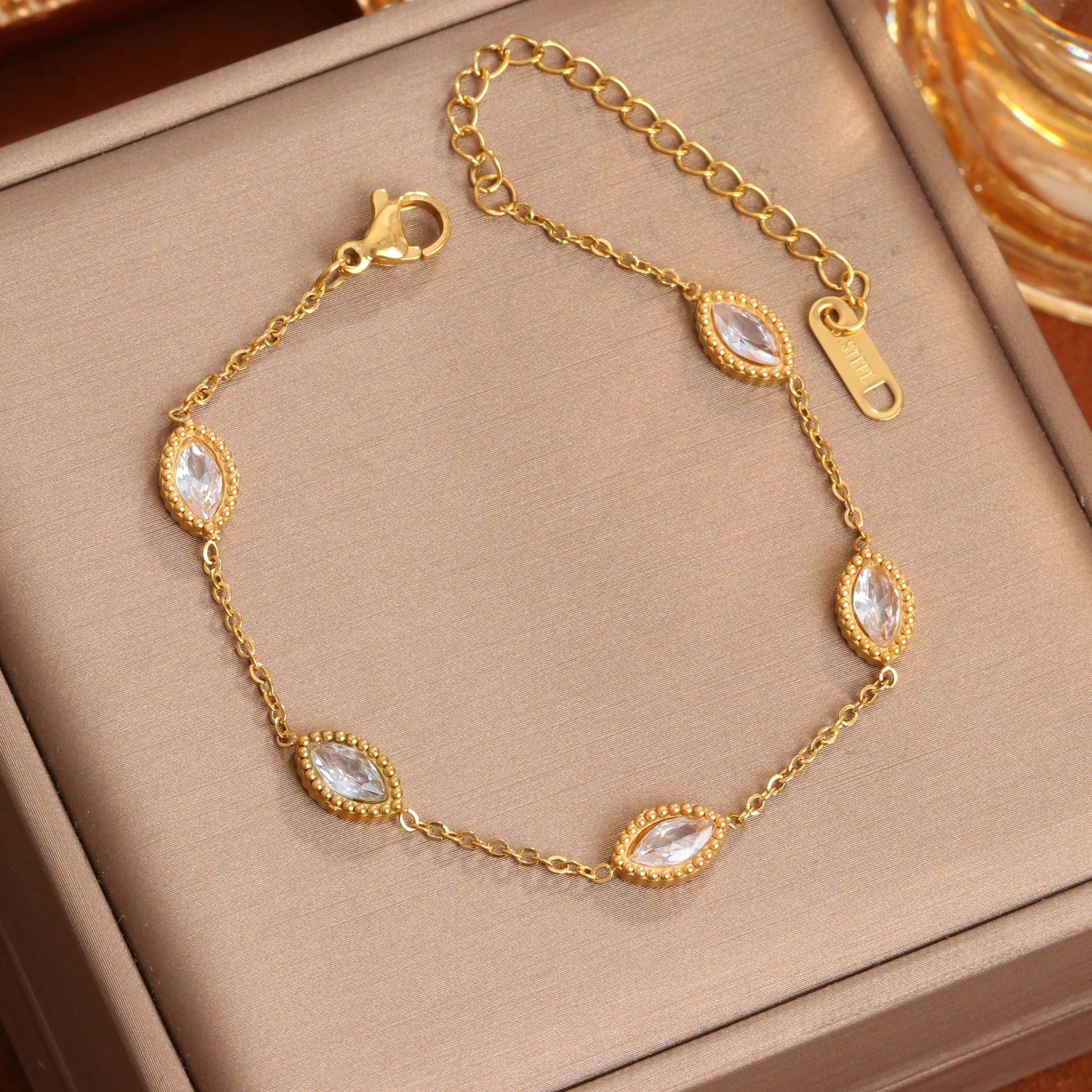 J29 - Pulsera con óvalos con circonias. Color dorado. Acero inoxidable.