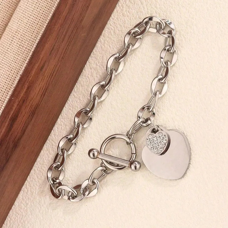 N20 - Pulsera con dijes de corazones con circonias. Color plateado. Acero inoxidable.