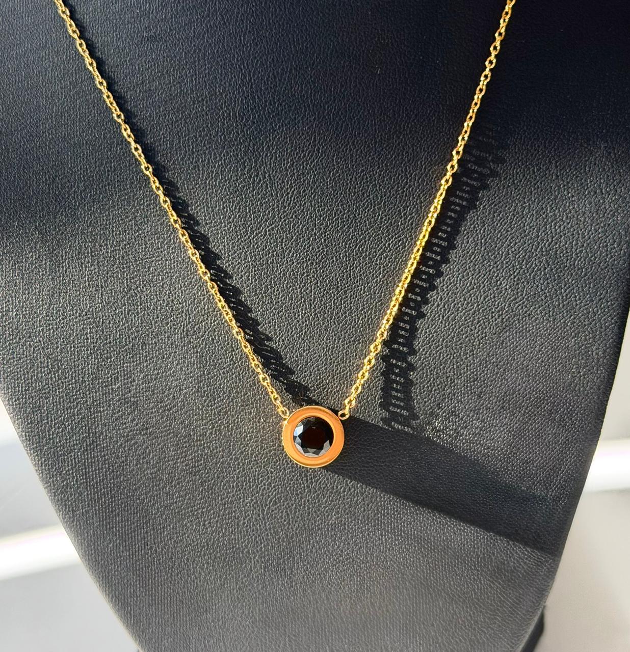 P05 - Collar con dije cristal negro redondo. Color dorado. Acero inoxidable.