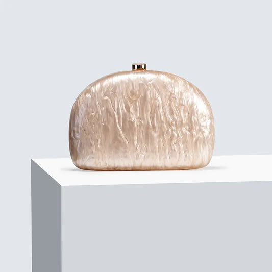 Bolsa tamaño chica. Color beige con efecto nacarado. Incluye correa para colgar cruzada.