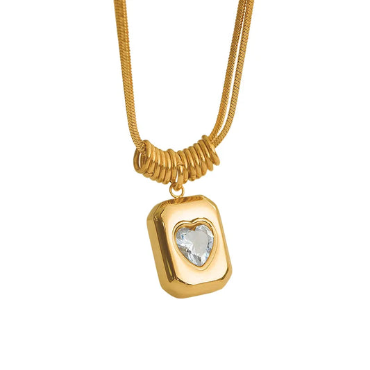 Collar con dije rectangular con corazón de circonia. Color dorado. Acero inoxidable.