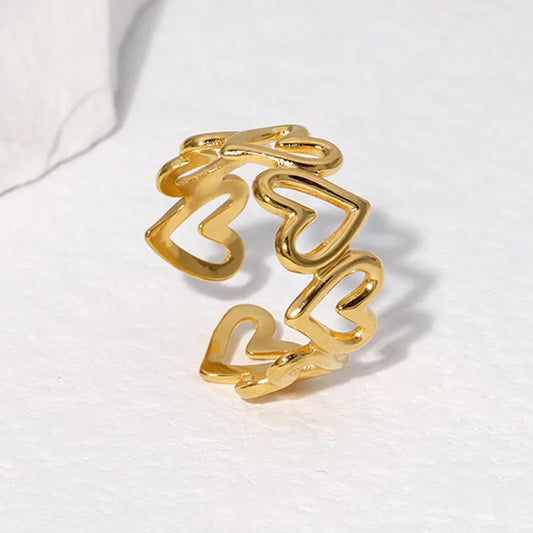 Anillo ajustable con corazones huecos. Color dorado. Acero innoxidable.