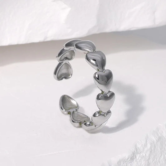 Anillo ajustable de corazones rellenos. Color plateado. Acero inoxidable.