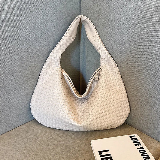 Bolsa grande, color hueso. Diseño entrelazado.