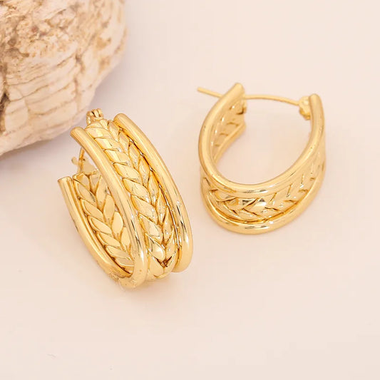 Arracadas ovaladas con diseño tipo trenza. Color dorado. Acero inoxidable.