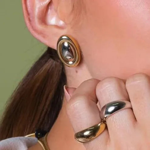Aretes medianos en forma de óvalo. Color dorado con plateado. Acero inoxidable.