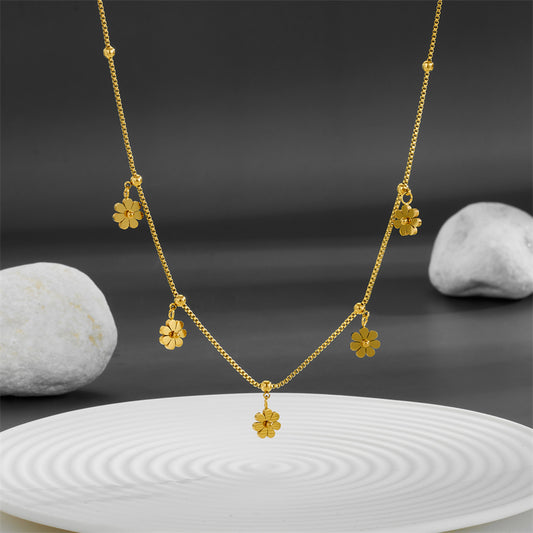 Cadena delgada con varios dijes de florecita. Color dorado. Acero inoxidable.