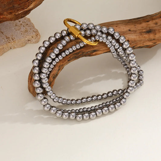 Pulsera triple, 3 tamaños con broche ovalado. Color platedo con dorado. Acero inoxidable.