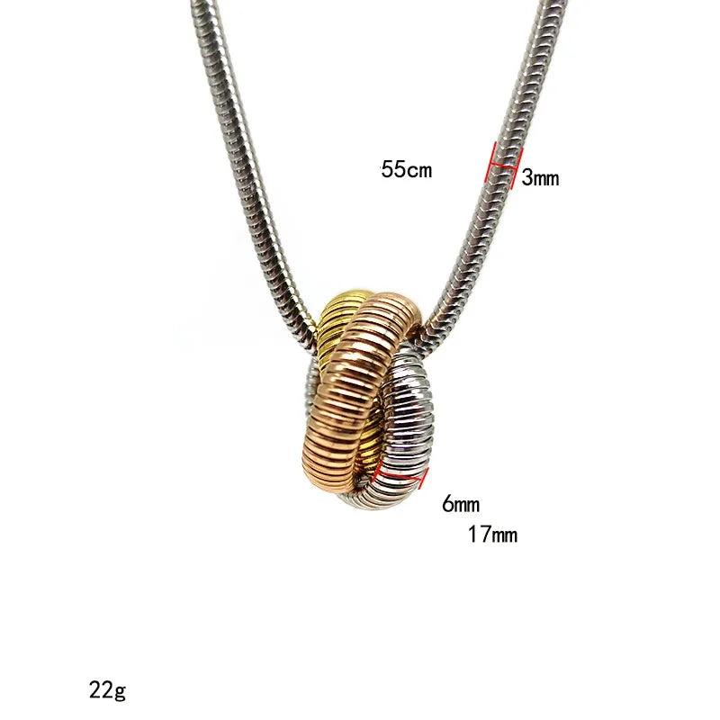Collar largo con dije entrelazado. Color de cadena plateada, dije tricolor: plateado, dorado y oro rosado. Acero inoxidable.