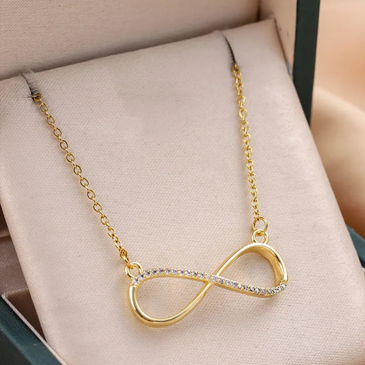 Collar con dije grande forma de infinito con circonia. Color dorado. Acero inoxidable.