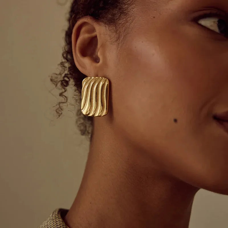 Aretes rectángulos grandes con líneas. Color dorado. Acero inoxidable.