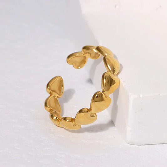 Anillo ajustable de corazones rellenos. Color dorado. Acero inoxidable.