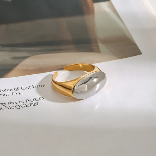 Anillo con óvalo frontal. Color dorado con plateado. Acero inoxidable.