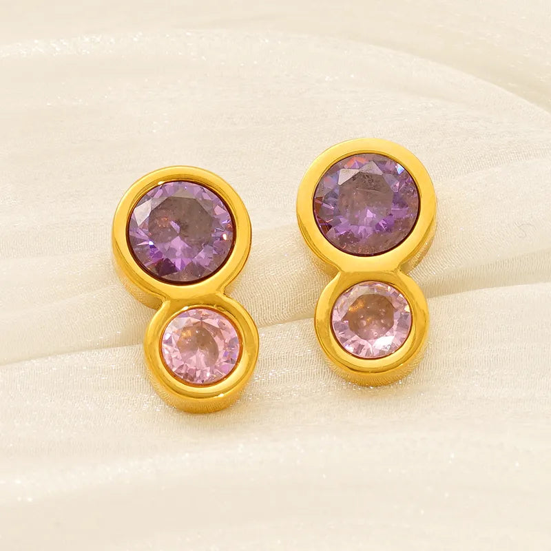 Aretes doble circulo con circonias morada y rosa. Color dorado. Acero inoxidable.