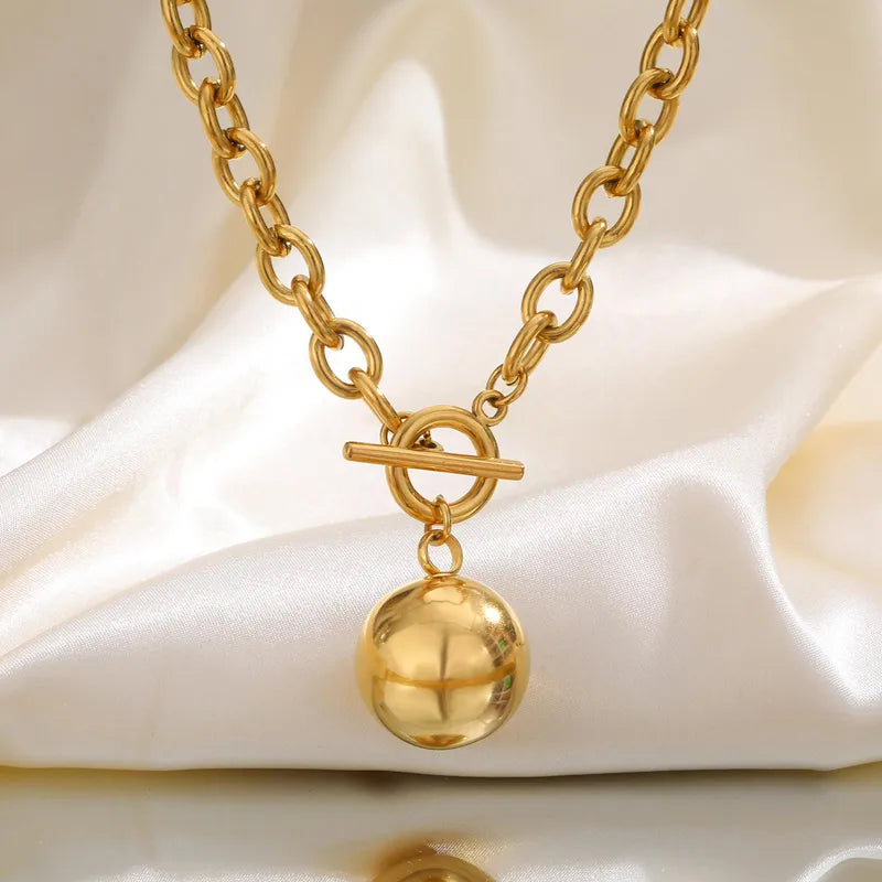 Collar de eslabones con dije de esfera. Color dorado. Acero inoxidable.