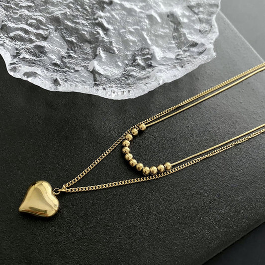 Collar doble con dije de corazón. Color dorado. Acero inoxidable.