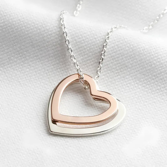 B05 - Collar con doble dije de corazón. Color plateado con rose gold. Acero inoxidable.