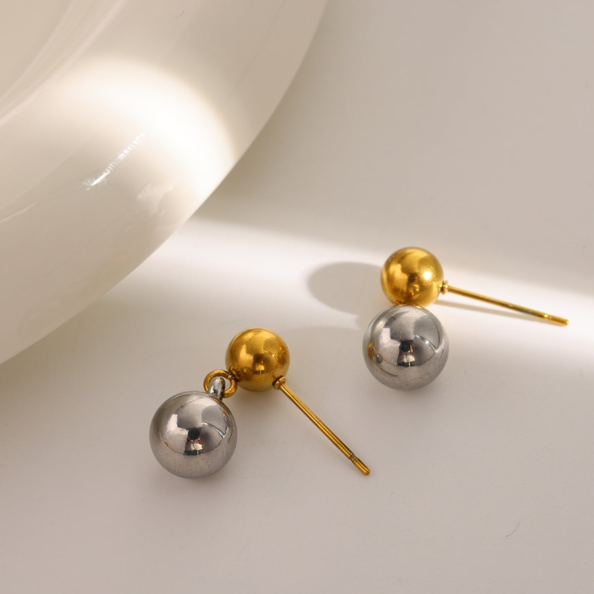 B20 - Aretes doble esferita. Color dorado y plateado. Acero inoxidable.