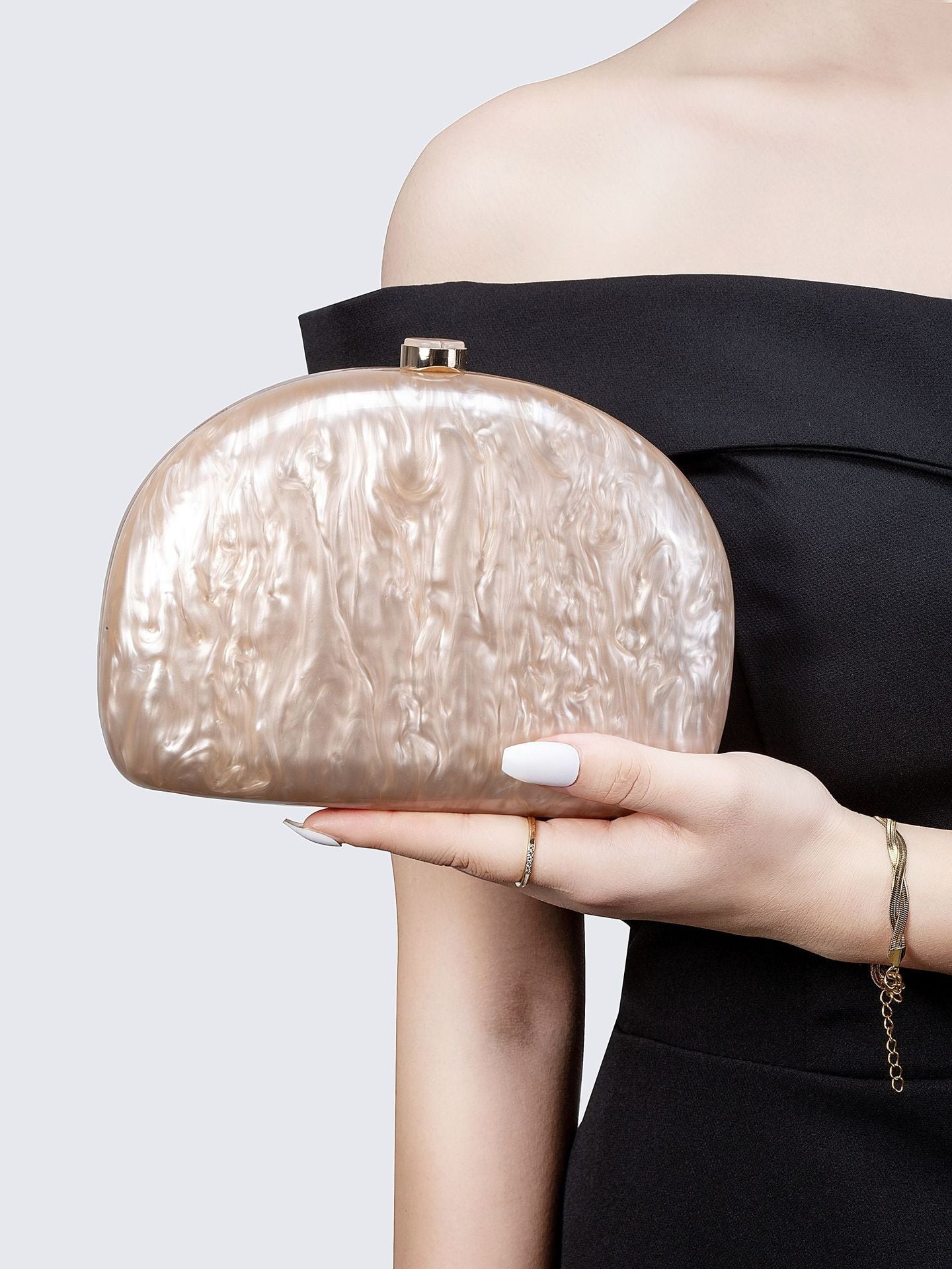 Bolsa tamaño chica. Color beige con efecto nacarado. Incluye correa para colgar cruzada.
