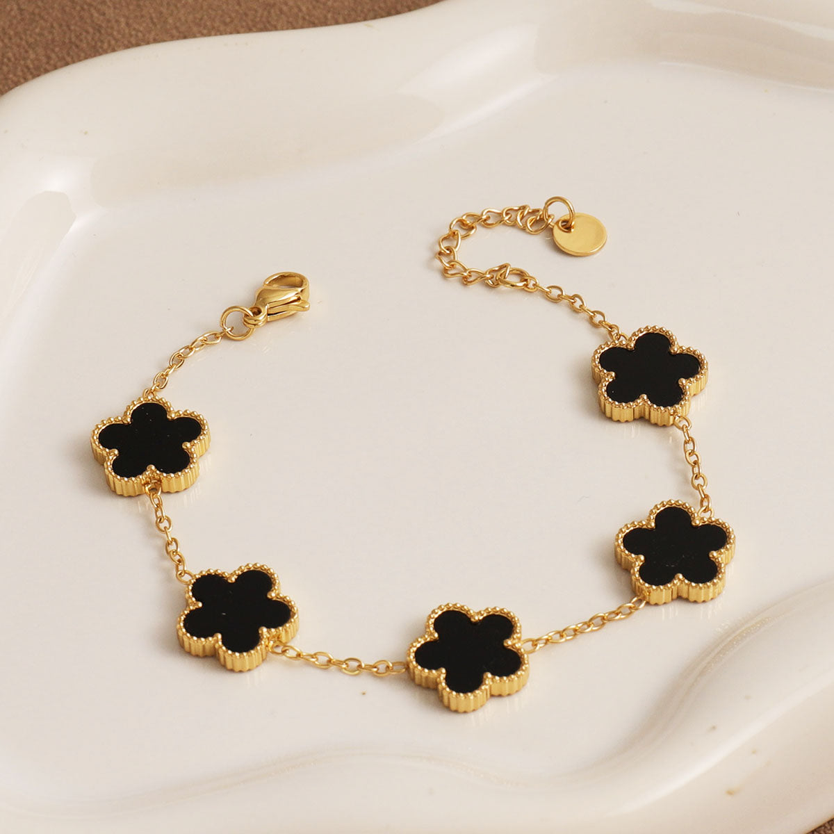 C09 - Pulsera flores. Color dorado con ncegro. Acero inoxidable.