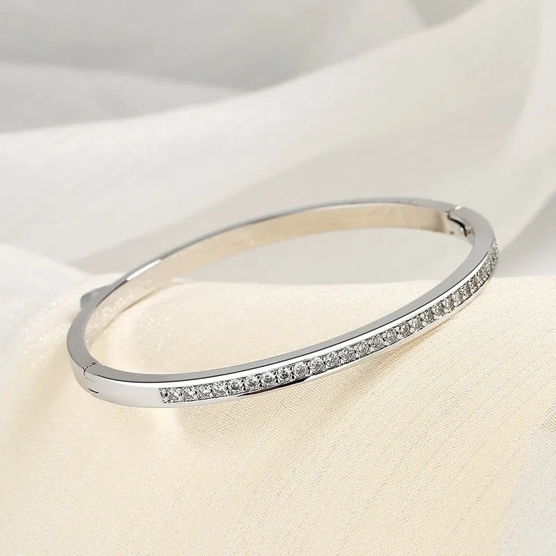 C22 - Pulso rigido con circonias. Color plateado. Acero inoxidable.