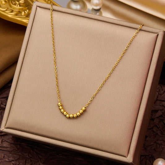 D08 - Collar con dijes de bolitas. Color dorado. Acero inoxidable.