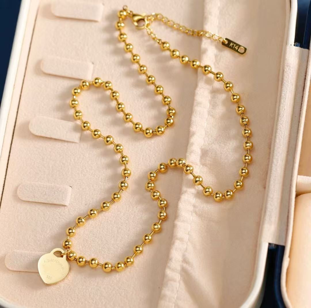 E03 - Collar con dije. Color dorado. Acero inoxidable.
