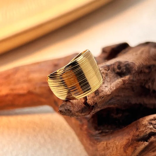 E06 - Anillo grueso con textura, ajustable. Color dorado. Acero inoxidable.