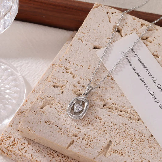 E15 - Collar con dije con circonia en forma de corazón. Color plateado. Acero inoxidable.