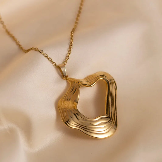 F05 - Collar con dije con forma. Color dorado. Acero inoxidable.