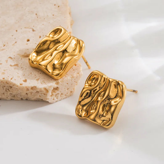 F14 - Aretes chicos de cuadros con relieve. Color dorado. Acero inoxidable.