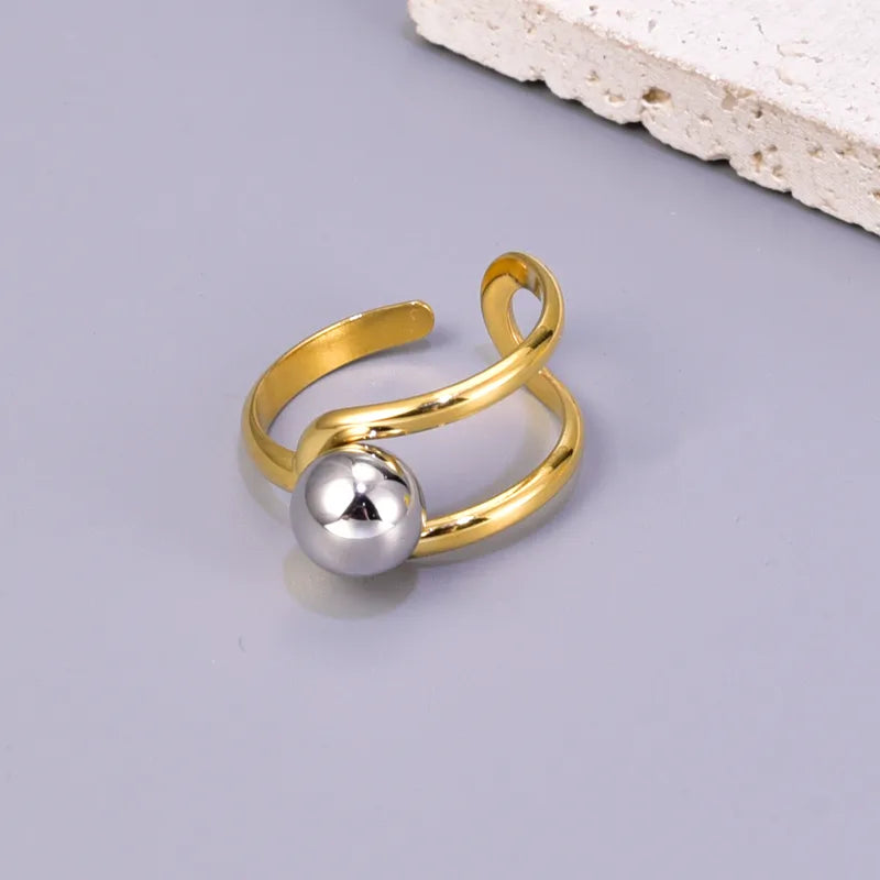 J17 - Anillo con esfera, ajustable. Color dorado con plateado. Acero inoxidable.