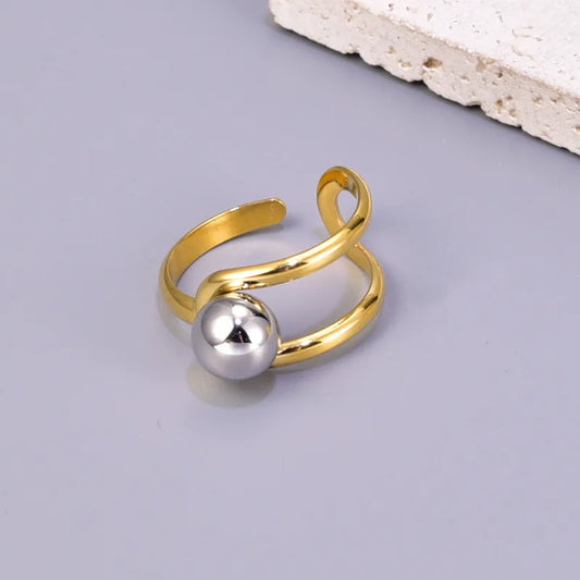 J17 - Anillo con esfera, ajustable. Color dorado con plateado. Acero inoxidable.