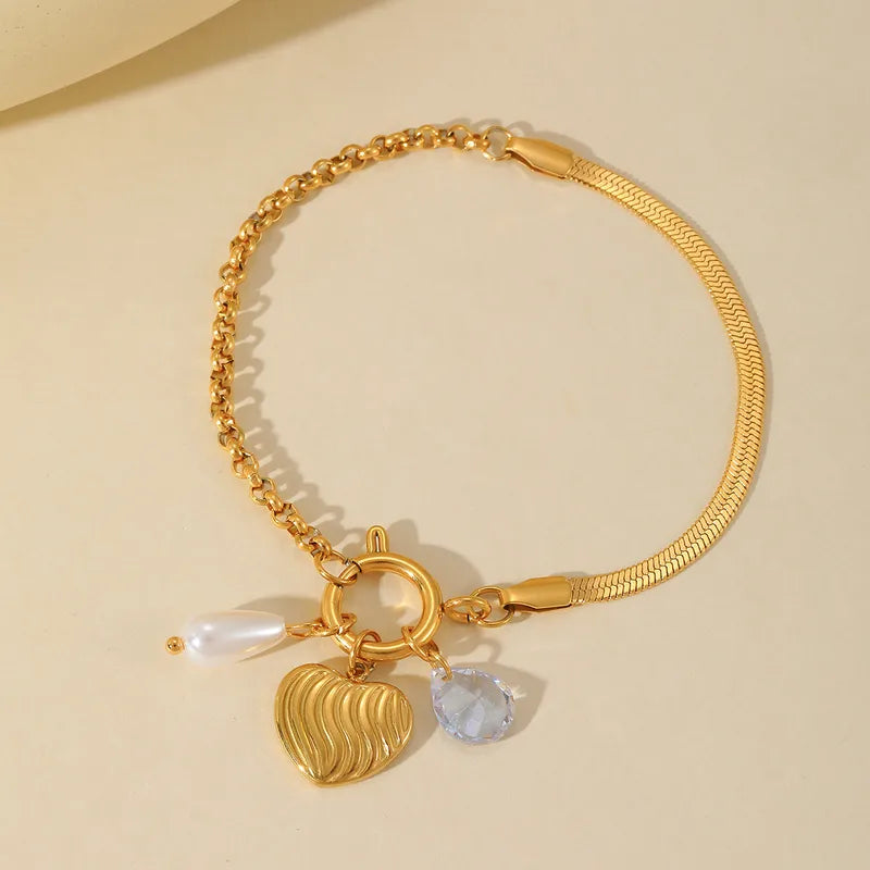 R02 - Pulsera con 3 dijes. Color dorado. Acero inoxidable.