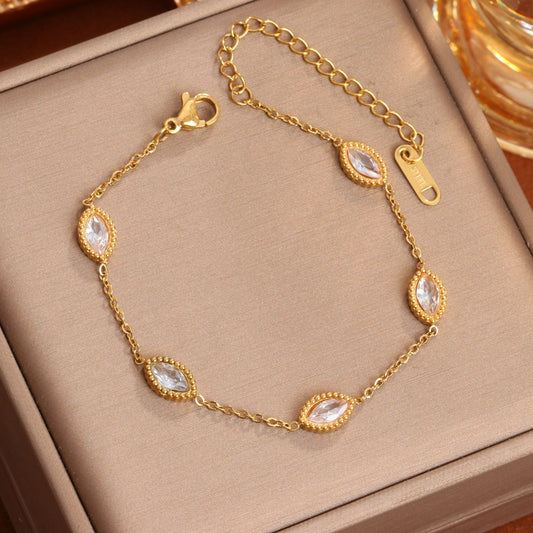 J29 - Pulsera con óvalos con circonias. Color dorado. Acero inoxidable.