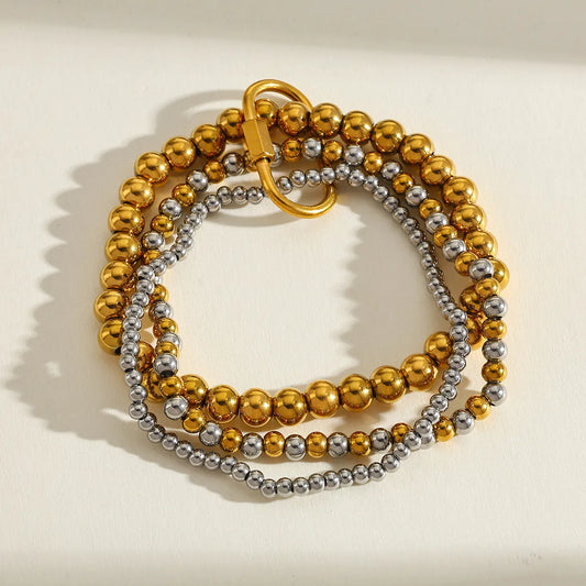 J35 - Pulsera triple de bolitas. Color dorado con plateado. Acero inoxidable.