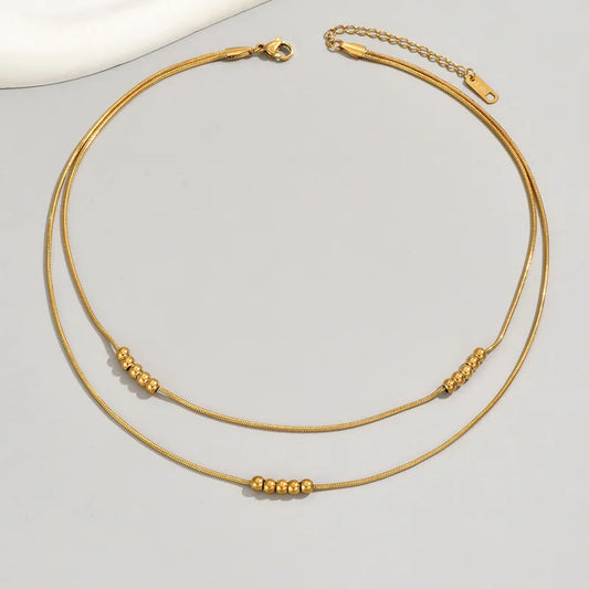 K01 - Collar doble con bolitas. Color dorado. Acero inoxidable.