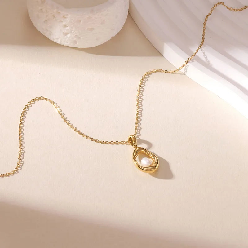 K02 - Collar con dije con perlita. Color dorado. Acero inoxidable.