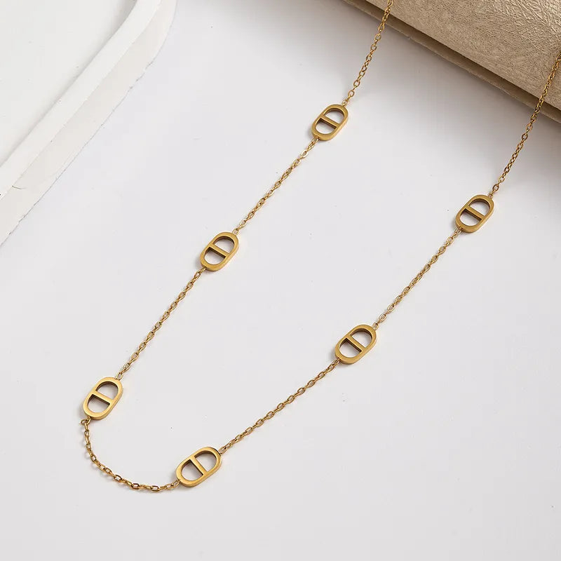 K03 - Collar cadena con varios dijes. Color dorado. Acero inoxidable.