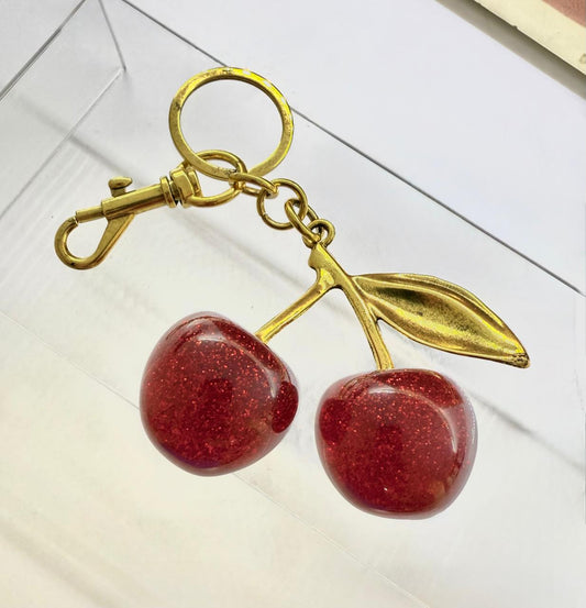 K06 - Llavero de cerezas de latón con resina, hojas color dorado.