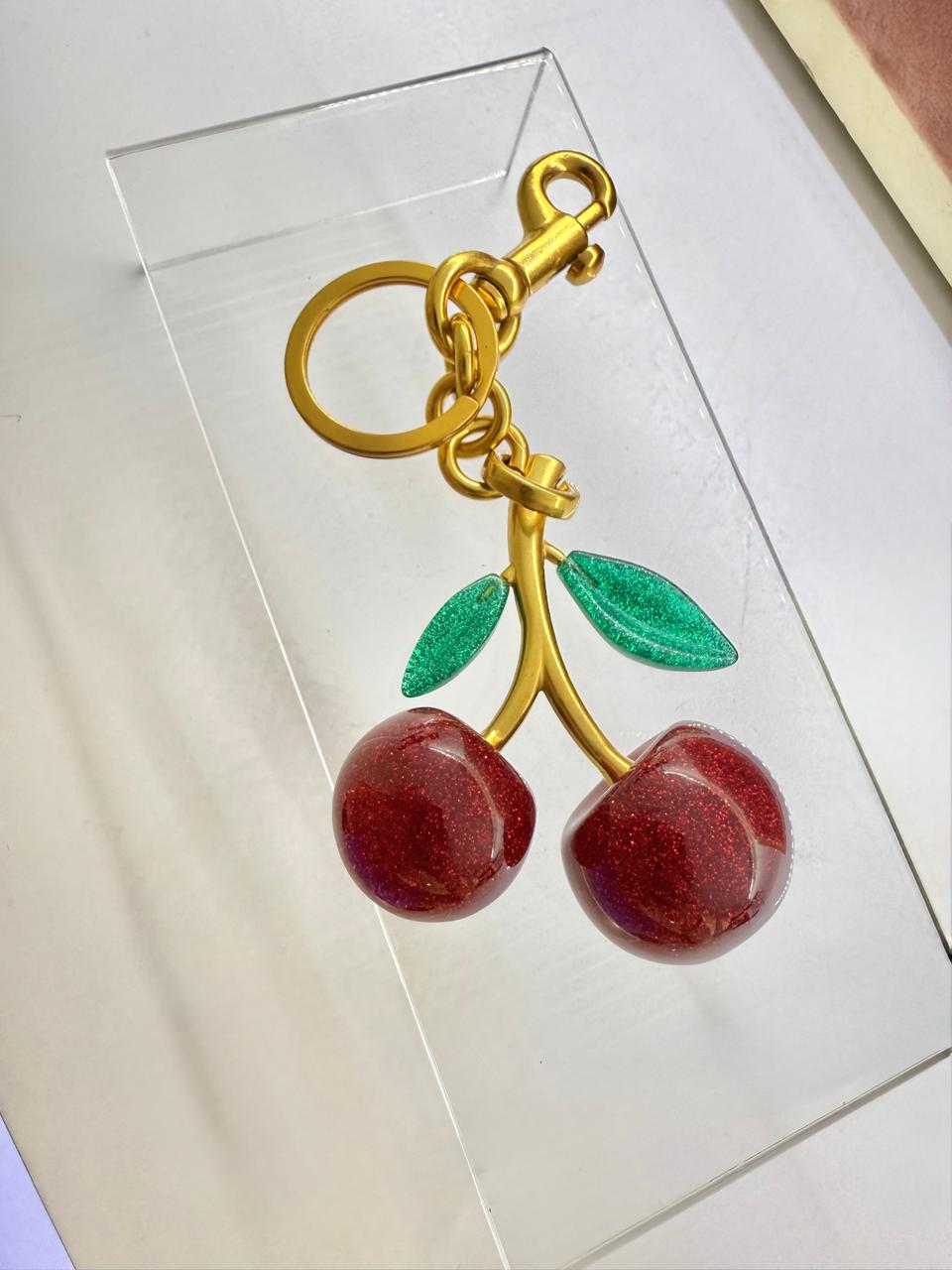 K07 - Llavero de cerezas de latón con resina, hojas color verde.