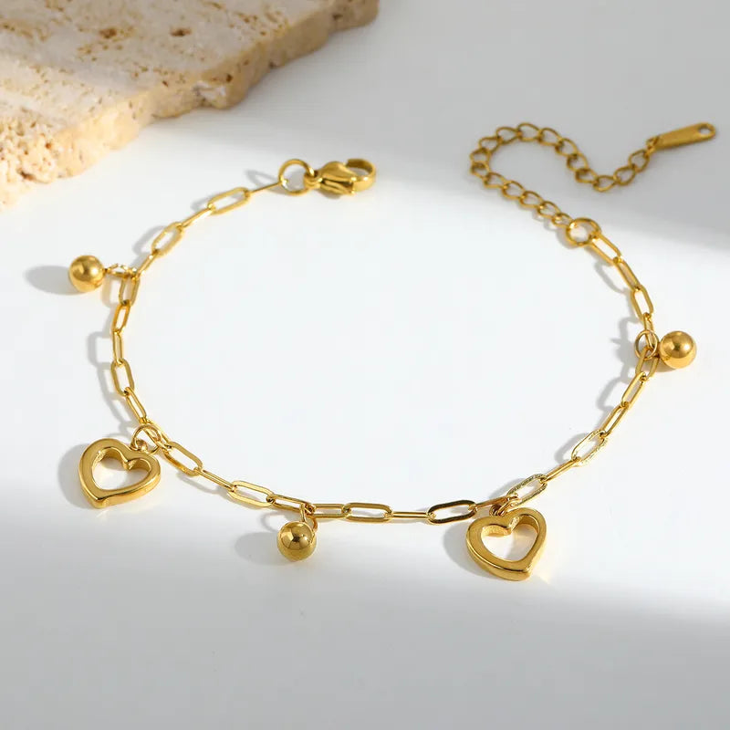 L04 - Pulsera cadena con dijes. Color dorado. Acero inoxidable.